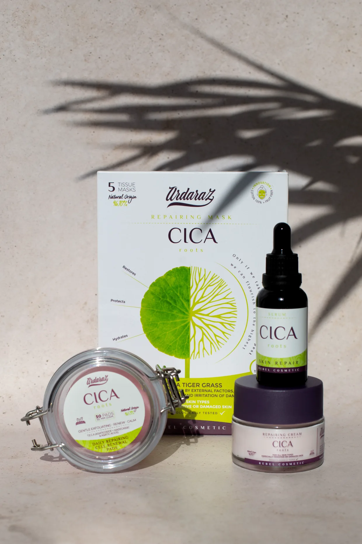La caja de cinco sobres de la mascarilla CICA junto al resto de la línea CICA, sobre una superficie de piedra clara.