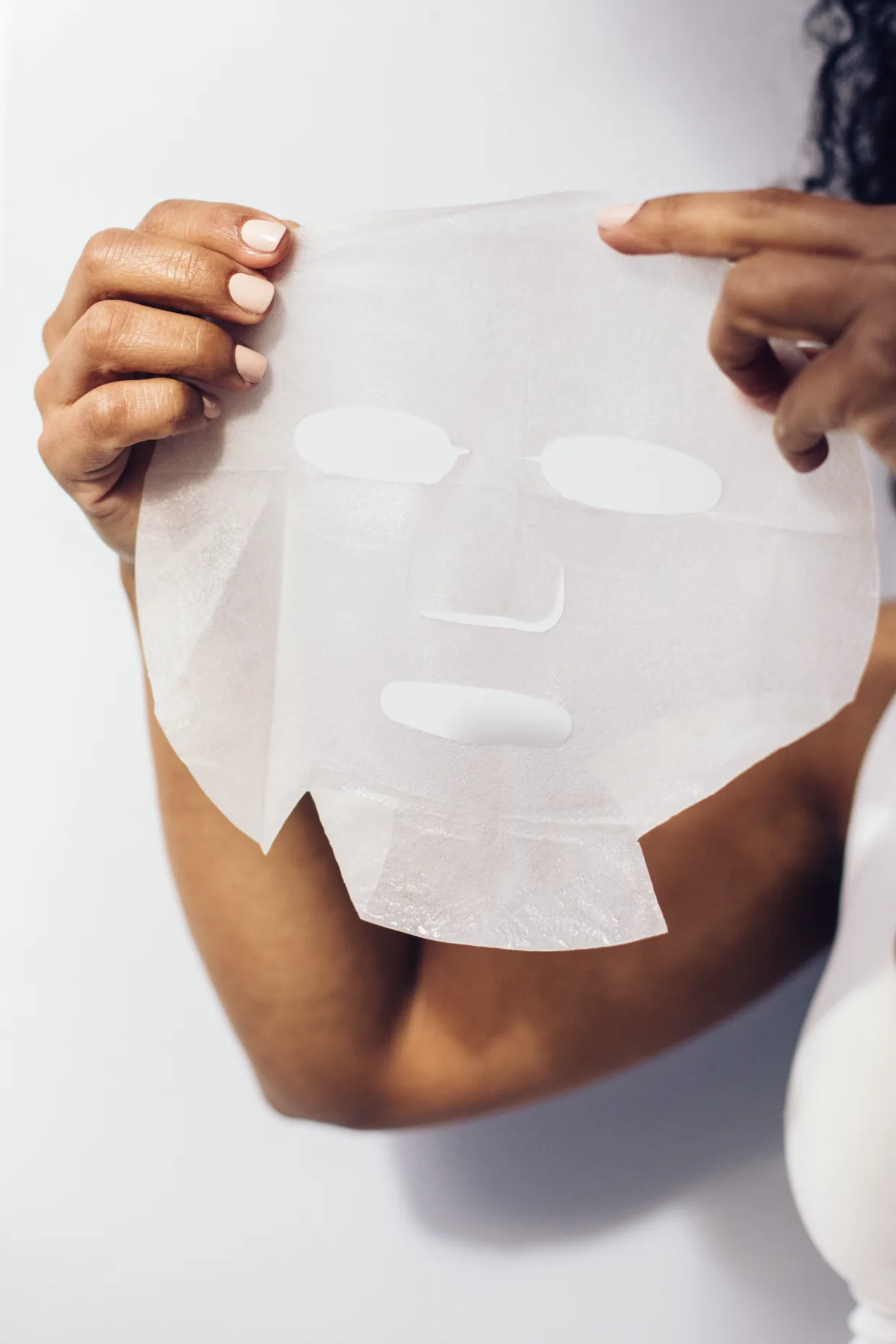 El tejido de la mascarilla desplegado entre las manos, antes de aplicarlo.