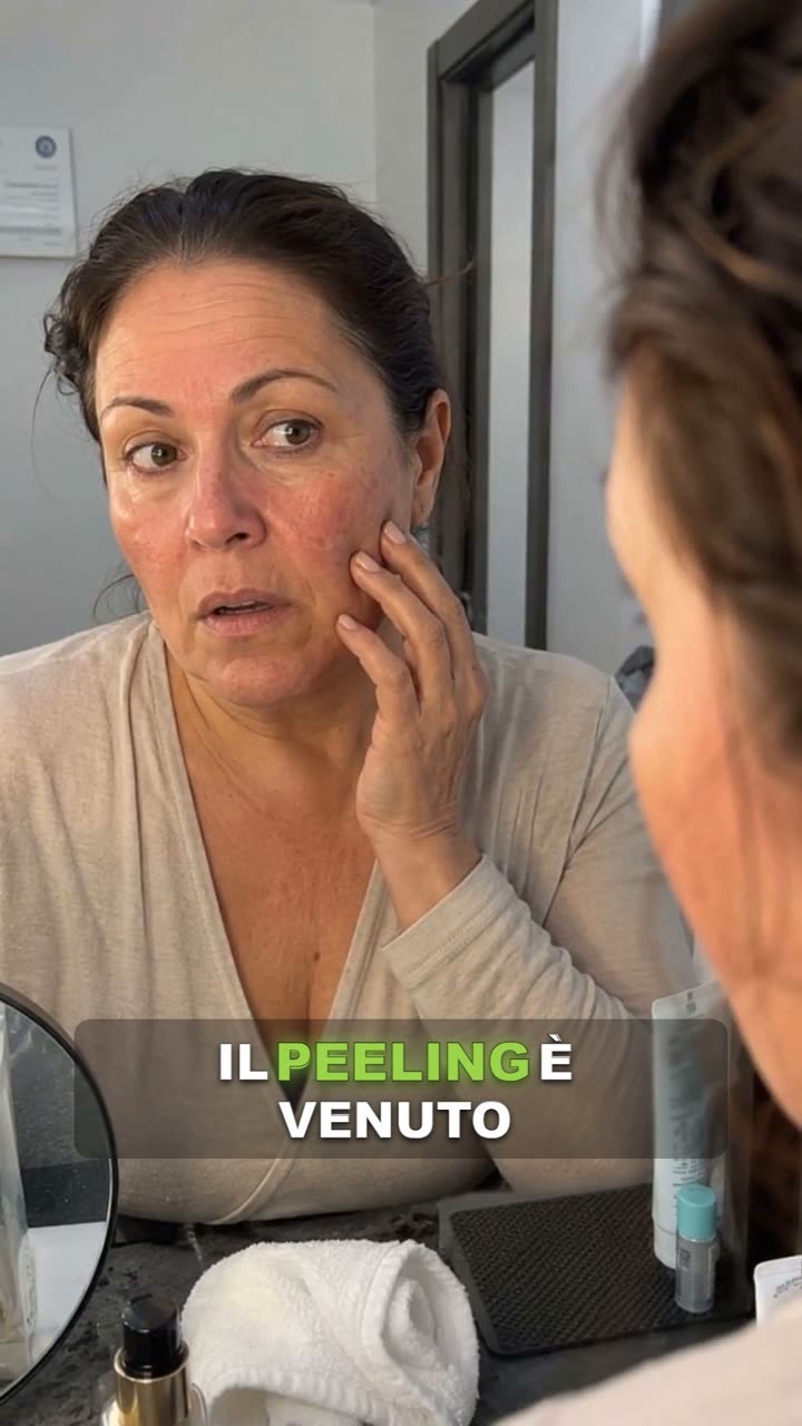 Una cliente che si guarda la pelle del viso.